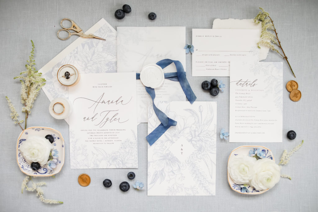 Full invitation suite layflat or flatlay photograph from a blue and white themed wedding at Fenway hotel in Dunedin Florida